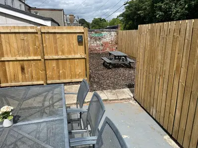 a backyard with a wooden fence and a picnic table at Elder Park Apartments in Glasgow