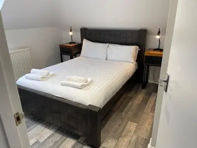 a bedroom with a large bed with two night stands at Elder Park Apartments in Glasgow