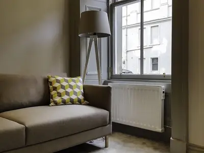 a living room with a couch and a window at Edinburgh Nine in Edinburgh