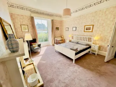 a large bedroom with a bed and a window at Lauriston Park in Edinburgh