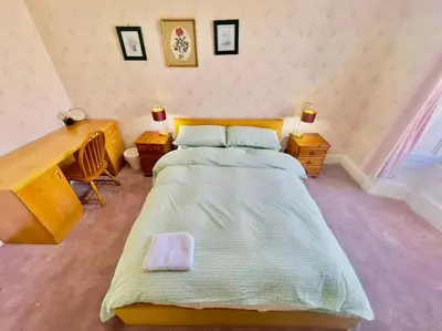 a bedroom with a large bed and a desk at Lauriston Park in Edinburgh