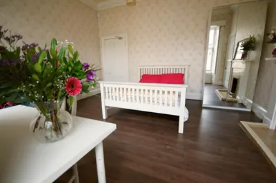 a living room with a white bench and a vase of flowers at Lauriston Park in Edinburgh