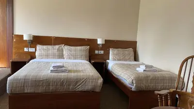 a hotel room with two beds with towels on them at Bonkle House in Wishaw