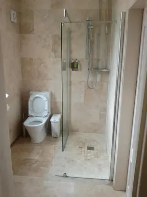a bathroom with a toilet and a shower with a glass door at Bonkle House in Wishaw