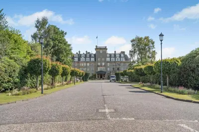 an empty street in front of a large building at The Pines - Luxury 3-Bed Apartment Near Golf & Spa, Gleneagles, Auchterarder in Auchterarder