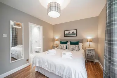 a bedroom with a bed with two towels on it at The Pines - Luxury 3-Bed Apartment Near Golf & Spa, Gleneagles, Auchterarder in Auchterarder