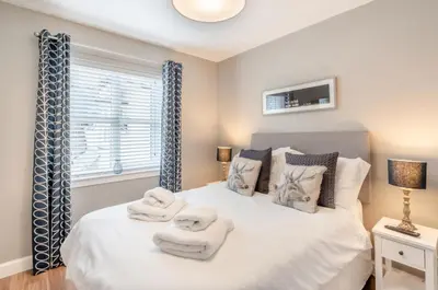 a bedroom with a bed with towels on it at The Pines - Luxury 3-Bed Apartment Near Golf & Spa, Gleneagles, Auchterarder in Auchterarder