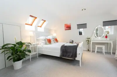 a white bedroom with a bed and a mirror at JustB Edinburgh in Edinburgh
