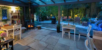 a patio with a table and chairs and a fireplace at JustB Edinburgh in Edinburgh