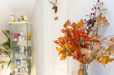 a vase with autumn leaves in a room at JustB Edinburgh in Edinburgh