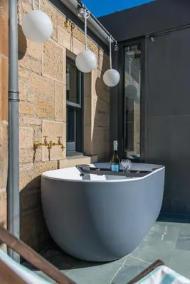 a large white tub sitting in the middle of a bathroom at Garden Rooms Edinburgh in Edinburgh