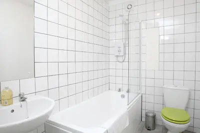a bathroom with a tub and a toilet and a sink at Southside Apartment Glasgow in Glasgow