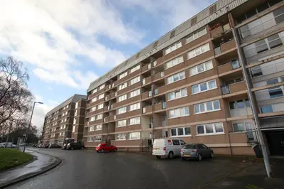 a large building with cars parked in a parking lot at Southside Apartment Glasgow in Glasgow