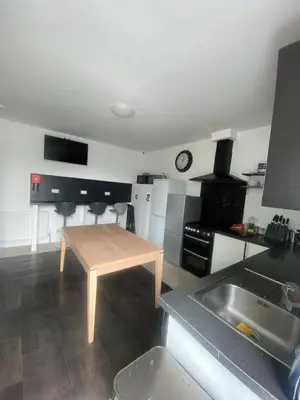 a kitchen with a table in the middle of a room at Edinburgh West Side Hostel in Edinburgh