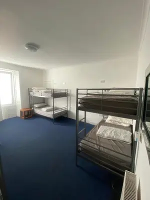 two bunk beds in a room with blue carpet at Edinburgh West Side Hostel in Edinburgh