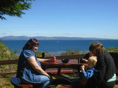 two women and a child sitting at a picnic table at Fonn Na Mara in Campbeltown