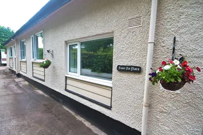 a sign on the side of a building with flowers at Fonn Na Mara in Campbeltown