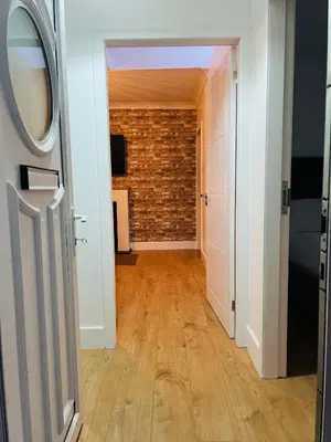 a hallway with a brick wall and an open door at Whiteley's Cottages in Dumbarton