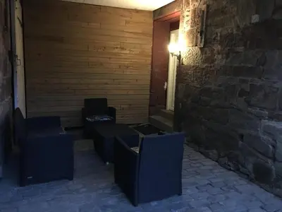 a room with chairs and a window and a brick wall at Whiteley's Cottages in Dumbarton