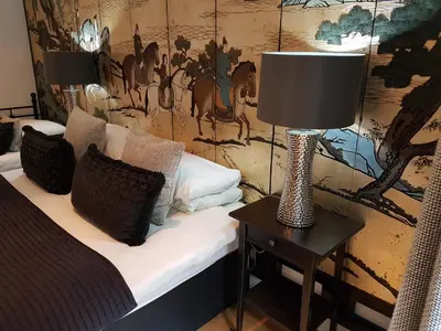 a room with a bed and a lamp on a table at Boat House Super Suites in Rothesay