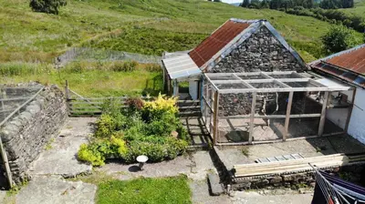 an old house with a greenhouse and some plants at Garrison Farm with Hot Tub in Inversnaid