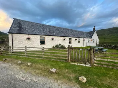 a white house with a fence in front of it at Garrison Farm with Hot Tub in Inversnaid