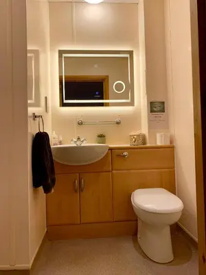 a bathroom with a sink and a toilet and a mirror at Garrison Farm with Hot Tub in Inversnaid