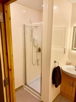 a bathroom with a shower and a sink at Garrison Farm with Hot Tub in Inversnaid
