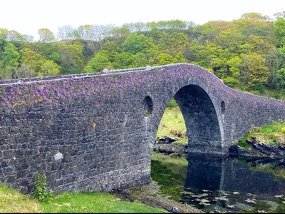 an old stone bridge over a body of water at Tramway Cottages in Ellanbeich