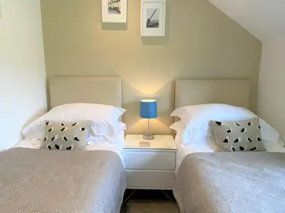 two beds sitting next to each other in a bedroom at Tramway Cottages in Ellanbeich