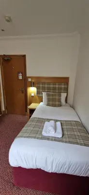 a hotel room with a bed with a towel on it at Loch Long Hotel in Arrochar