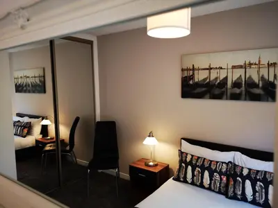 a hotel room with a bed and a desk and a bedroom at Mycosy 605 in Paisley