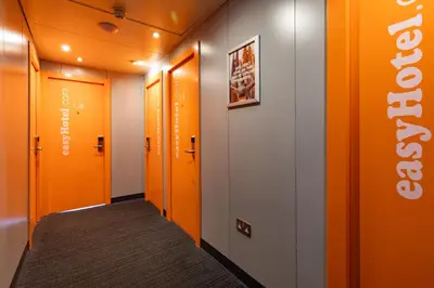a hallway with orange doors and a sign on the wall at easyHotel Edinburgh in Edinburgh