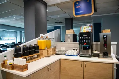 a coffee shop with a coffee maker on a counter at Holiday Inn Express - Glasgow - City Ctr Riverside by IHG in Glasgow