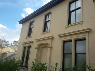 a tan house with windows at Crosshill House in Glasgow