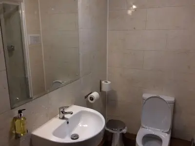 a bathroom with a sink and a toilet and a mirror at Crosshill House in Glasgow