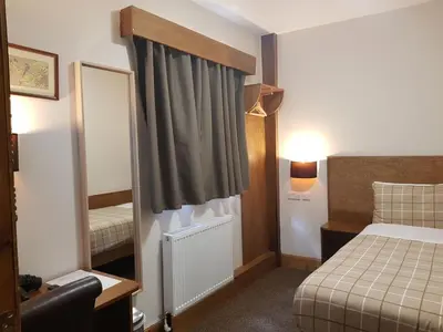 a hotel room with a bed and a mirror at Crosshill House in Glasgow