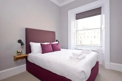 a bedroom with a large bed with purple accents at Destiny Scotland - Distillers House in Edinburgh