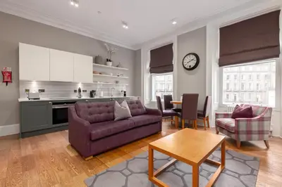 a living room with a purple couch and a table at Destiny Scotland - Distillers House in Edinburgh