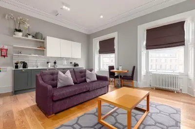 a living room with a purple couch and a table at Destiny Scotland - Distillers House in Edinburgh