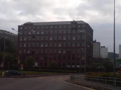 a large brick building on a city street at Loft Apartment in Port Glasgow