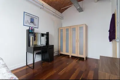 a living room with white walls and a wooden floor at Loft Apartment in Port Glasgow