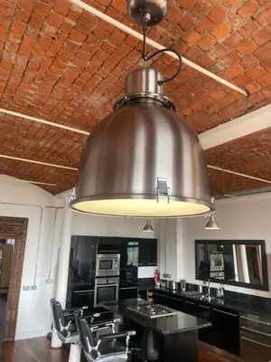 a large metal light hanging from a ceiling at Loft Apartment in Port Glasgow