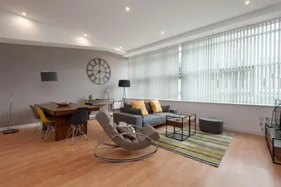 a living room with a couch and a table at Glasgow City Flats - Merchant City in Glasgow