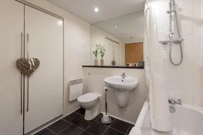 a bathroom with a sink and a toilet and a shower at Glasgow City Flats - Merchant City in Glasgow