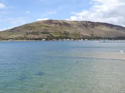 a large body of water with a hill in the background at The Shieling in Lochranza
