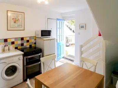 a small kitchen with a table and a microwave at Ivybank Cottage in Lamlash