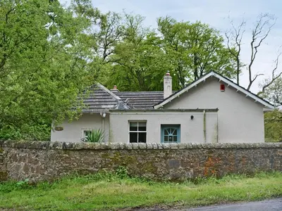 a white house behind a stone wall at Fernwoodlea in Blairhall