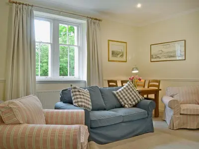a living room with a blue couch and a chair at Fernwoodlea in Blairhall