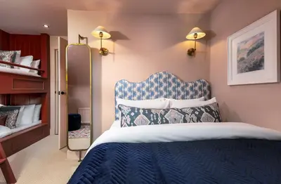 a bedroom with a blue and white bed and shelves at Munro Guest House in Stirling